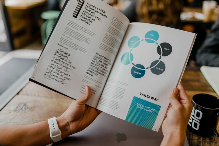 Person reading a business strategy book at cafe table