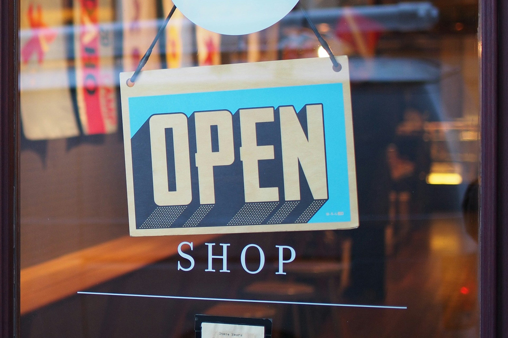 Blue 'OPEN' sign hanging on a shop window