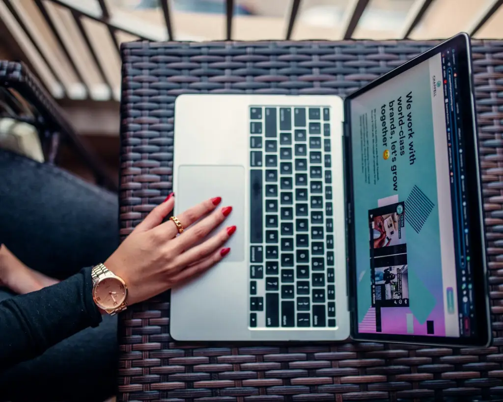 Woman using laptop with website display on screen