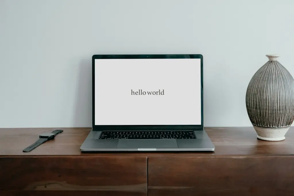 Laptop on desk displaying 'hello world' text