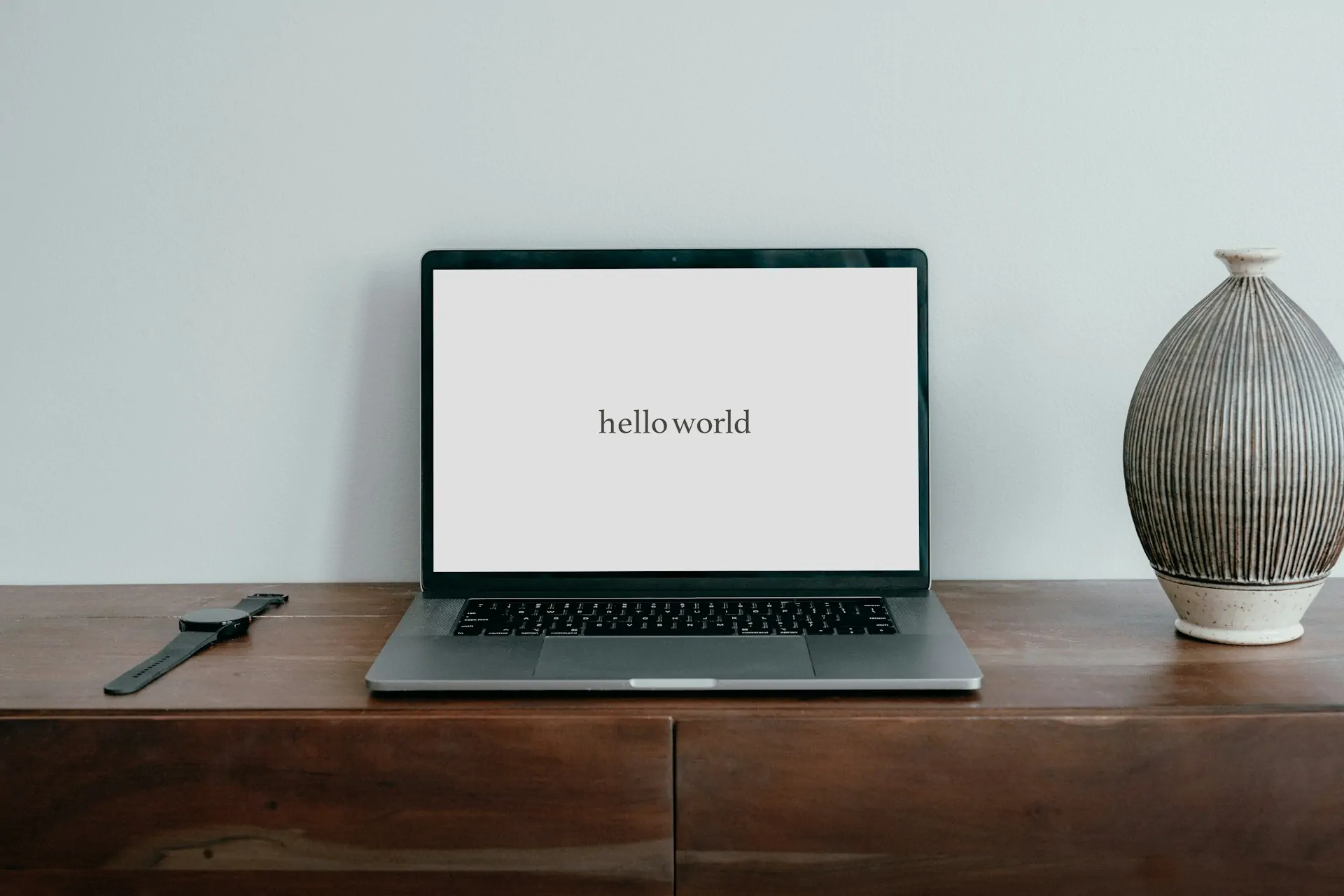 Laptop on desk displaying 'hello world' text