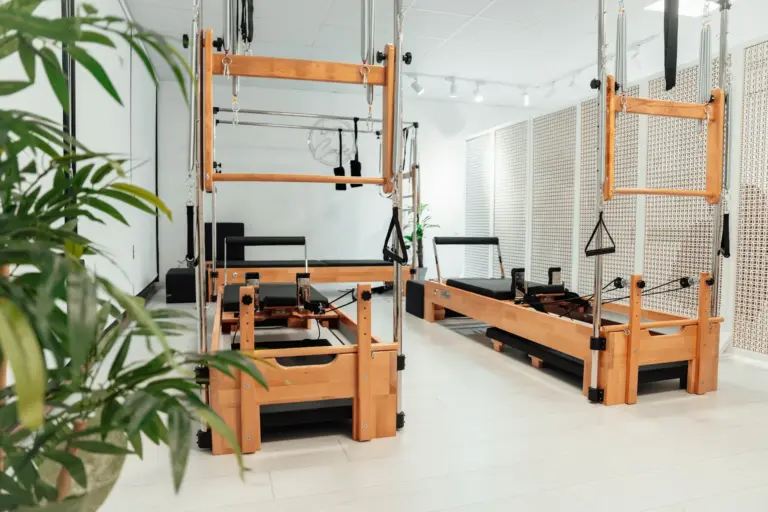 Modern Pilates reformer machines in bright studio